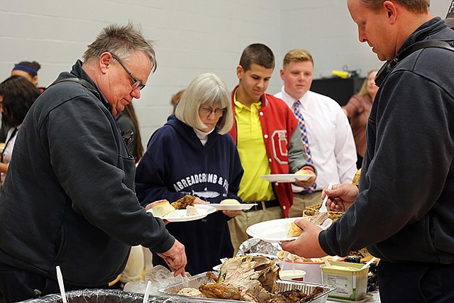Jefferson City firefighters Capt. Kevin Bagby, left, and Tom Gann, right, attend the annual Thanksgiving luncheon Tuesday at Calvary Lutheran High School. The luncheon included a prayer service followed by food.