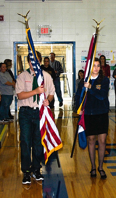 The Missouri State flag and the U.S. flag are brought in to the Jamestown gym to be posted for the Veterans Day Assembly on Nov. 11.