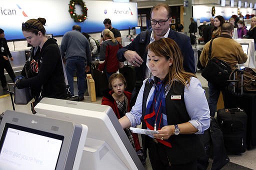 Travelers check in at the American Airlines ticket counter at O'Hare International Airport in Chicago, Wednesday, Nov. 23, 2016. Almost 49 million people are expected to travel 50 miles or more for the Thanksgiving holiday, the most since 2007, according to AAA. 