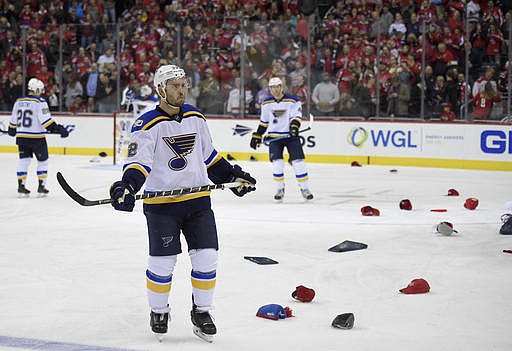 St. Louis Blues defenseman Kevin Shattenkirk (22) waits as hats litter the ice after Washington Capitals left wing Alex Ovechkin scored his third goal of the night for a hat trick during the third period of an NHL hockey game, Wednesday, Nov. 23, 2016, in Washington. The Capitals won 4-3.