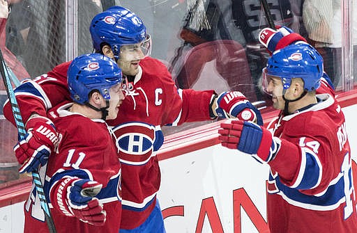 Montreal Canadiens' Max Pacioretty (67) celebrates with teammates Tomas Plekanec (14) and Brendan Gallagher (11) after scoring against the Carolina Hurricanes during the third period of an NHL hockey game in Montreal, Thursday, Nov. 24, 2016. (Graham Hughes/The Canadian Press via AP)