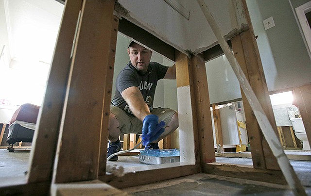 Jason Meier paints flood damaged wall studs in his flood-damaged home Nov. 3 in Virginia Beach, Virginia. Hundreds of homes in the area were damaged from floodwaters from the remnants of Hurricane Matthew.