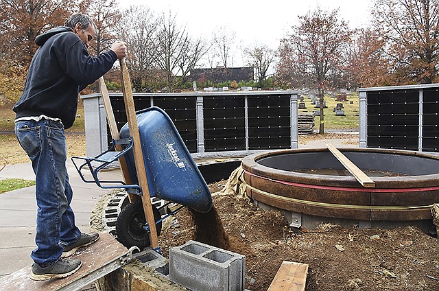 Danny Fuller empties one of several wheelbarrow loads of dirt into the enclosed circular area surrounding the fountain base of the newly-built columbarium at Riverview Cemetery. It is located very near the Hawkins Memorial in the western part of the cemetery. The columbarium will feature a lighted fountain and seating around the outside edge of the fountain. 