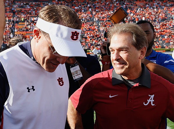 In this Nov. 28, 2015, file photo, Alabama head coach Nick Saban (right) and Auburn head coach Gus Malzahn meet before last season's Iron Bowl game in Auburn, Ala.