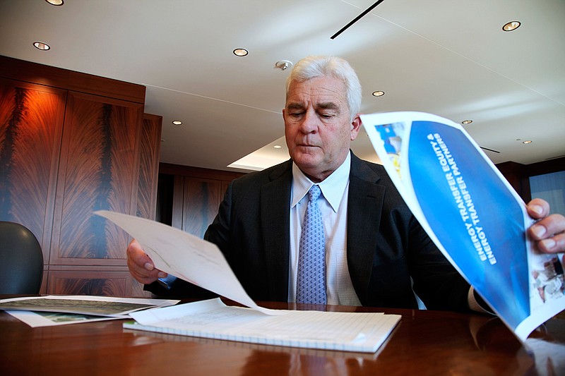 In this Friday, Nov. 18, 2016, file photo, Energy Transfer Partners CEO Kelcy Warren reviews documents at his office in Dallas on  the Dakota Access oil pipeline that is mired in controversy after thousand of protestors have sought to block its expansion underneath a water source close to the Standing Rock Sioux Indian Reservation in North Dakota. President-elect Donald Trump holds stock in the company building the disputed Dakota Access oil pipeline, and pipeline opponents warn that Trump's investments could undercut any decision he makes on the $3.8 billion project as president.