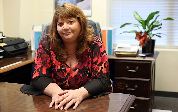 Susan Cook sits in her River City Habitat for Humanity office in Jefferson City. She is the new director for the organization, which helps to provide affordable homes for area residents.