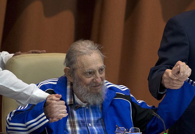 In this April 19, 2016 file photo, Fidel Castro sits as he clasps hands with his brother, Cuban President Raul Castro, right, and second secretary of the Central Committee, Jose Ramon Machado Ventura moments before the playing of the Communist party hymn during the closing ceremonies of the 7th Congress of the Cuban Communist Party, in Havana, Cuba. Castro has died at age 90. President Raul Castro said on state television that his older brother died late Friday, Nov. 25, 2016.