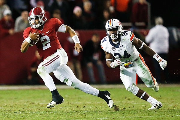 Alabama quarterback Jalen Hurts runs the ball against Auburn defensive back Daniel Thomas during the second half of Saturday's game in Tuscaloosa, Ala.