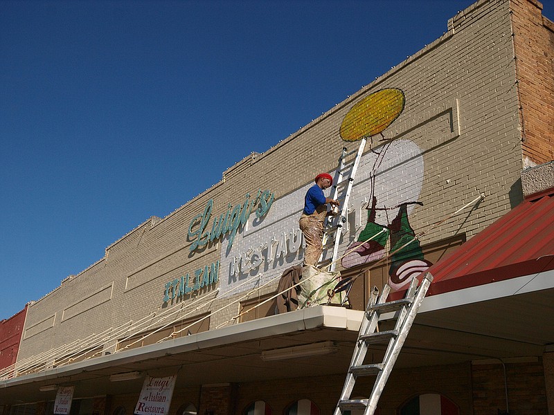 Cass County artist James Coleman works on a sign for Luigi's Restaurant in Atlanta, Texas. He said he sometimes works throughout the night to complete his tasks. Coleman provides much of the public art around Atlanta.