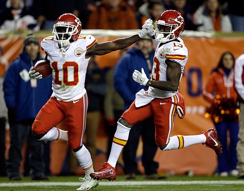 Tyreek Hill (10) high-fives Chiefs teammate De'Anthony Thomas as he runs back a free kick for a touchdown during the first half of Sunday night's game against the Broncos in Denver.