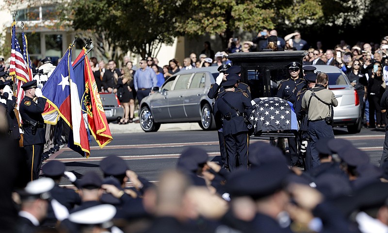 Police attend funeral services Monday for San Antonio police detective Benjamin Marconi, 50, a 20-year veteran of the force, as his casket is delivered by a horse-drawn carriage in San Antonio. Marconi was fatally shot Nov. 20 during a traffic stop near police headquarters.
