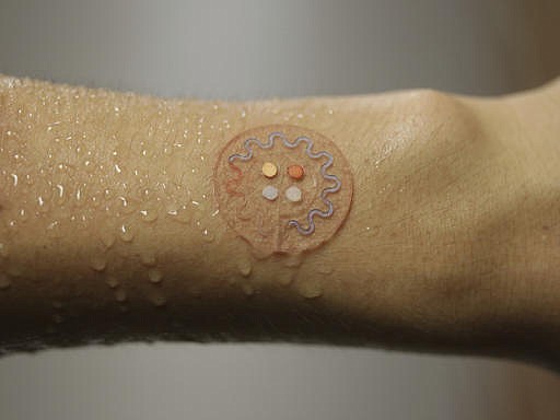This photo provided by J. Rogers, Northwestern University, shows a soft, skinmounted microfluidic device for capture, collection and analysis of sweat. Time to break a sweat: Researchers are creating a skin patch that can test droplets of sweat to track health while people exercise, beaming results to their smartphones. (J. Rogers, Northwestern University via AP)