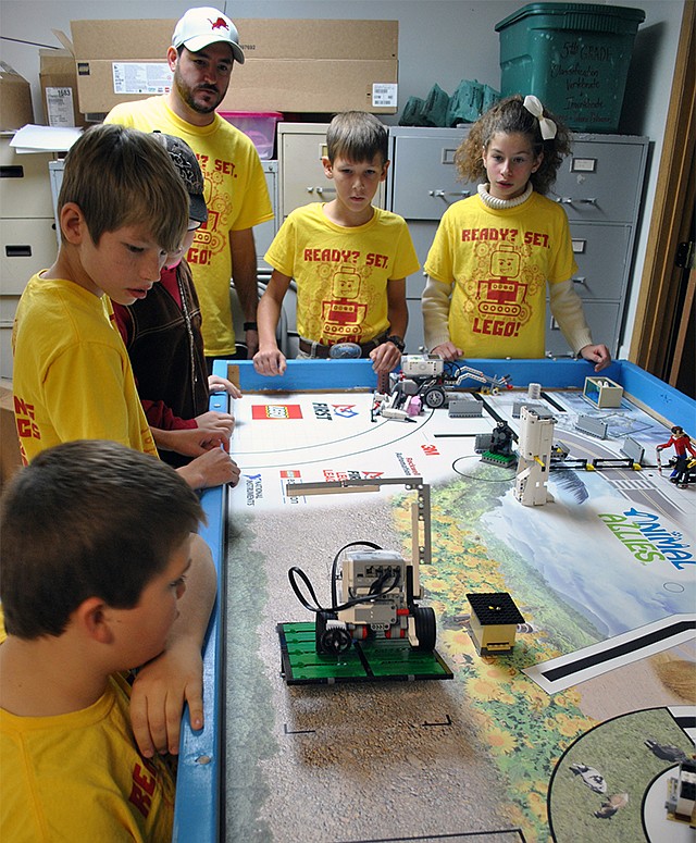 The T-Town Lions Robotics 25915 mentor Randy Gum, center, and team members, from front left, Jonah Viser, Devon Alexander, Lance Wieberg, Connor Kempker and Zoe Martonfi watch as their robot tries to complete a mission as part of the robot game during practice at Tuscumbia School.