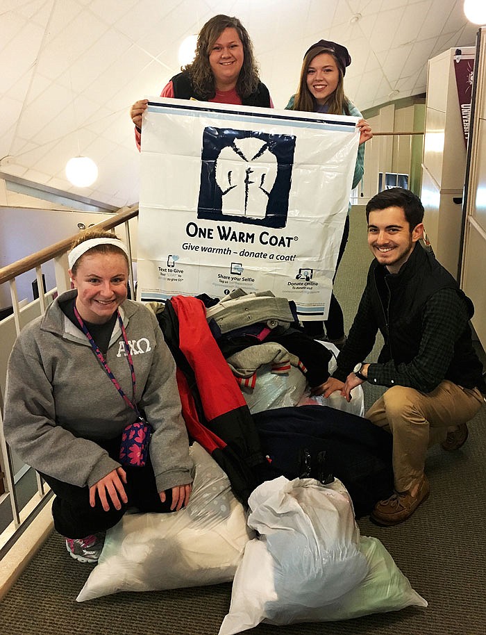 Members of the Rotaract Club of William Woods University, left to right, Emily Gast, Hannah Mansell, Ashley Pendleton and Matt Underwood display some of the bags of coats they've collected.