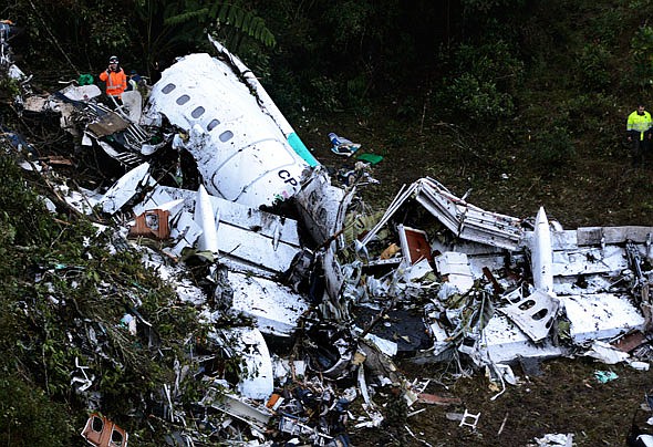 A rescue worker stands at the wreckage site of a chartered airplane that crashed in a mountainous area Tuesday outside Medellin, Colombia.