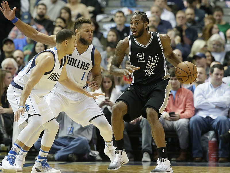 San Antonio Spurs forward Kawhi Leonard (2) dribbles against Dallas Mavericks defenders Justin Anderson (1) and Seth Curry (30) during the first half of an NBA basketball game in Dallas, Wednesday, Nov. 30, 2016. 