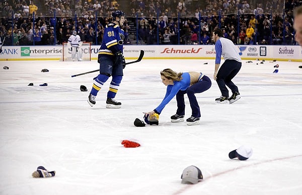 Vladimir Tarasenko of the Blues skates on the ice as workers pick up hats thrown onto the ice by fans during the third period in celebration after Tarasenko's third goal in Thursday night's game against the Lightning in St. Louis.