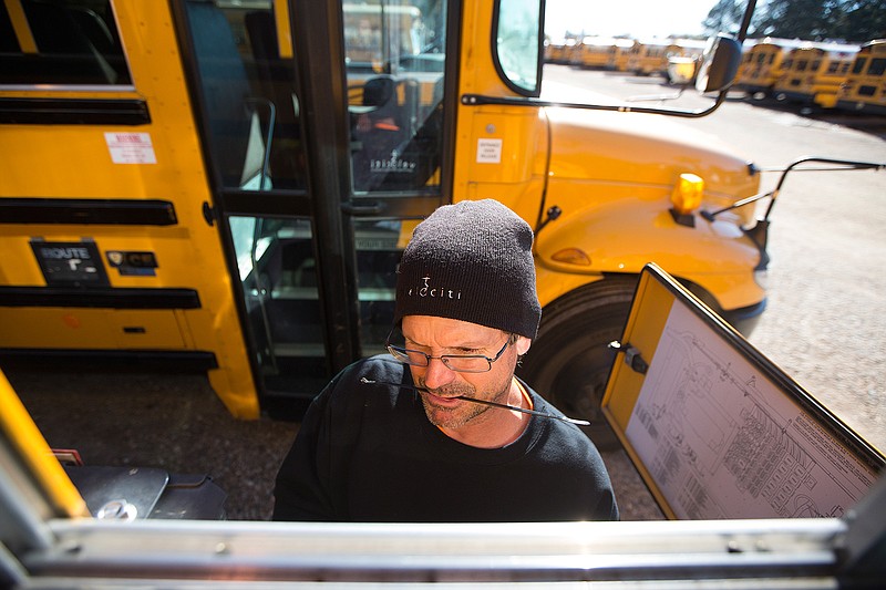 Paul Romaniuk, professional services technician with Velociti, installs a GPS system on one of the Texarkana, Ark., School District buses Thursday. TASD is having all of the district's buses equipped so that parents can track their child's bus in real time.
