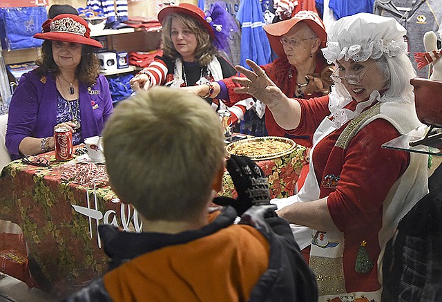 Connie Wade, right, waves at children Friday in Carrie's Hallmark during Living Windows. Wade was Mrs. Claus during the event.