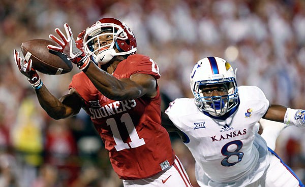 Oklahoma wide receiver Dede Westbrook makes a catch for a touchdown ahead of Kansas cornerback Brandon Stewart during a game earlier this season in Norman, Okla. 