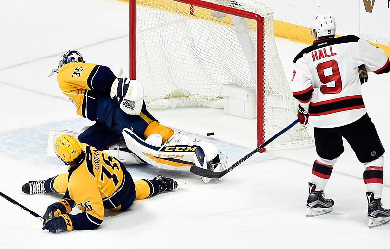 New Jersey Devils left wing Taylor Hall (9) watches a shot by teammate Michael Cammalleri get past Nashville Predators goalie Pekka Rinne (35), of Finland, for a goal in overtime of an NHL hockey game Saturday, Dec. 3, 2016, in Nashville, Tenn. The Devils won 5-4. 