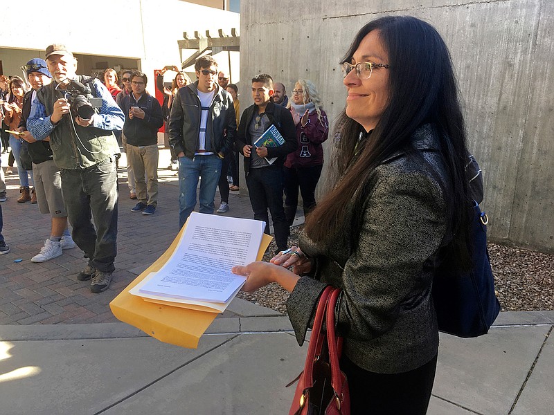 In this Nov. 18, 2016 file photo, University of New Mexico Chicana and Chicano studies professor Irene Vasquez holds a letter with hundreds of signatures, asking school president Bob Frank to declare the campus a "sanctuary university," in Albuquerque, N.M. Universities and colleges in several states are considering labeling themselves "sanctuary campuses" amid fears from immigrant students and pressure from activists following the election of Donald Trump.