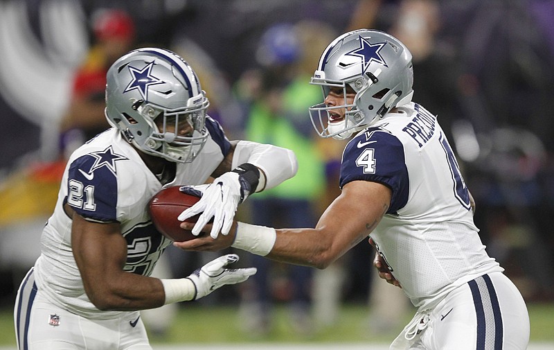 Dallas Cowboys quarterback Dak Prescott, right, hands the ball off to running back Ezekiel Elliott on Thursday during the first half against the Minnesota Vikings in Minneapolis. A season after going 4-12, the Cowboys are 11-1 and assured of at least a wild-card berth. 