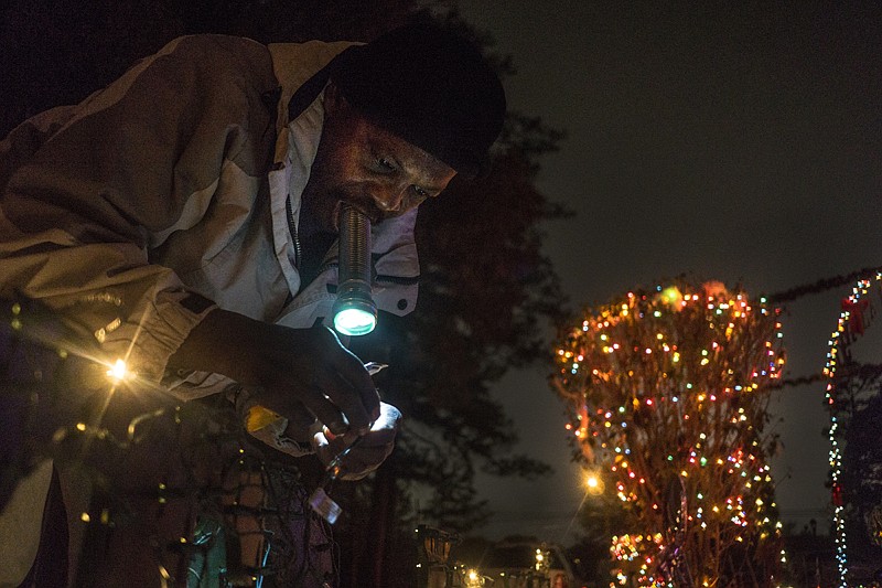 Finisour Koontt replaces a Christmas light fuse Monday in Mary Wadley's front yard on Wildwood Drive. Known for her extravagant Christmas displays, Wadley says this will be the last year for her light show in Texarkana. "We are moving toward the East Coast so this is the last year," Wadley said. "I'll keep the tradition going at my new home though. This is how I see Christmas."