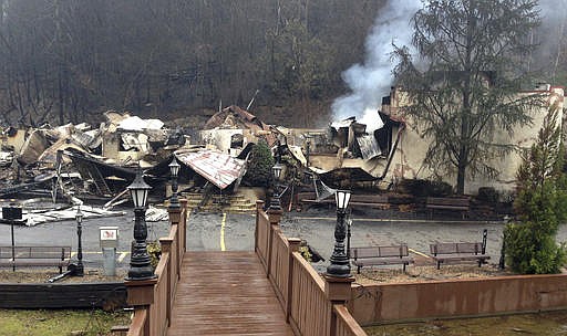 Smoke continues to rise from the Alamo Steakhouse in Gatlinburg, Tenn., Monday, Dec. 5, 2016, after it burned during deadly wildfires. Businesses remained closed Monday in the fire-ravaged Tennessee community but many were in cleanup mode in hopes of reopening to the public, possibly by midweek. 