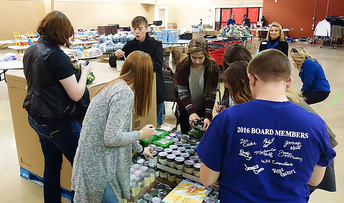 Student members of the Callaway Kids Bank board of directors sort through canned goods for SERVE Inc.