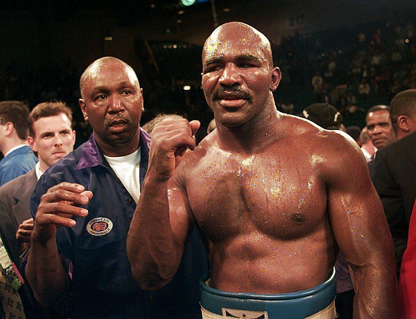 In this Nov. 9, 1996, file photo, Evander Holyfield raises his fist after defeating Mike Tyson in their WBA heavyweight championship bout at the MGM Grand Garden in Las Vegas. Holyfield and three-division champion Marco Antonio Barrera head a list of nine people selected for induction into the International Boxing Hall of Fame.