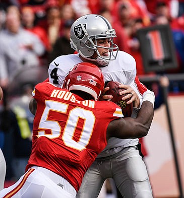 In this Dec. 14, 2014, file photo, Chiefs linebacker Justin Houston sacks Raiders quarterback Derek Carr during a game in Kansas City.