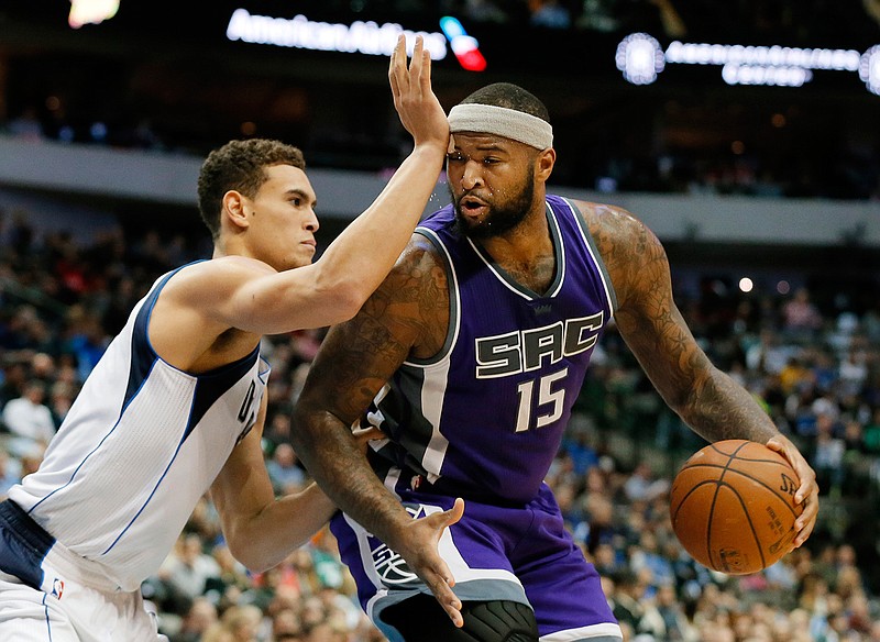 Sacramento Kings center DeMarcus Cousins (15) receives a blow to the head from Dallas Mavericks' Dwight Powell as Cousins works to get to the basket in the first half of an NBA basketball game, Wednesday, Dec. 7, 2016, in Dallas. 