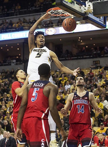 Missouri's Mitchell Smith, top, dunks the ball over Arizona's Chance Comanche, left, Kadeem Allen, center, and Dusan Ristic, right, during the first half of an NCAA college basketball game Saturday, Dec. 10, 2016, in Columbia, Mo. 