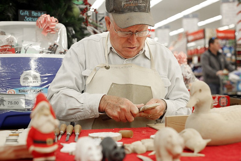 Woodcarver Shelby Jones carves Christmas ornaments Thursday at HyVee in Jefferson City. Jones is a member of Firehouse Woodcarvers Club, which will donate ornament proceeds to support the Central Missouri Honor Flight.