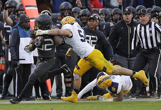 Army running back Kell Walker, left, tries to outrun Navy linebacker Taylor Heflin, center, and safety Alohi Gilman in the first half of the Army-Navy NCAA college football game in Baltimore, Saturday, Dec. 10, 2016.