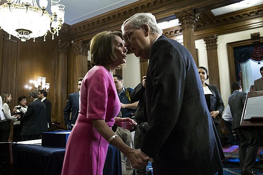 In this Dec. 8, 2016 file photo, House Minority Leader Nancy Pelosi of Calif. speaks with Senate Majority Leader Mitch McConnell, of Ky. on Capitol Hill in Washington. 