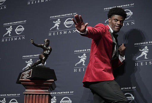 Louisville's Lamar Jackson poses with the Heisman Trophy after winning the award Saturday, Dec. 10, 2016, in New York.