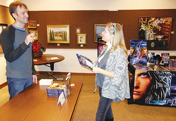 At left, Adam Veile chats with Jamie Shepherd during Sunday's Local Author Showcase at Missouri River Regional Library. Veile is a local author with two books in his "The Dreamcatcher Adventure" series, while Shepherd has just written a book called "The Dumb Blonde Approach"she hopes to market. The event was a chance for authors to interact with each other and with their readers.