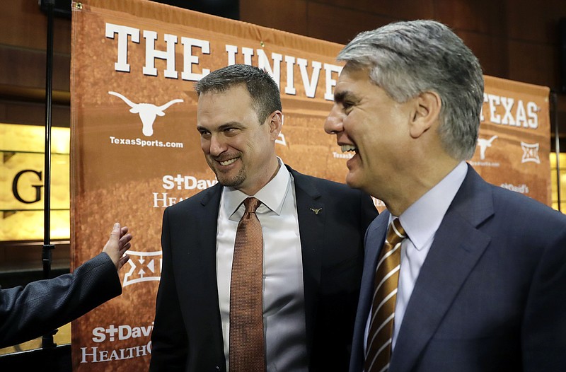 New Texas head NCAA college football coach Tom Herman, left, and president Gregory Fenves, right, leave a news conference where Herman was introduced to the media, Sunday, Nov. 27, 2016, in Austin. 