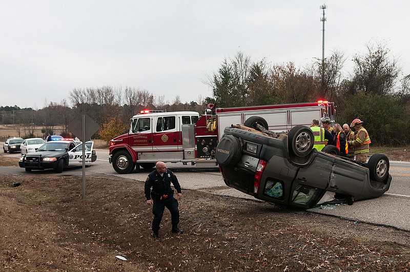 Cpl. Les Munn of the Texarkana, Ark., Police Department inspects a Honda CR-V that was involved in a rollover accident with a Richardson Waste Inc. truck Friday on Genoa Road in Texarkana, Ark. 