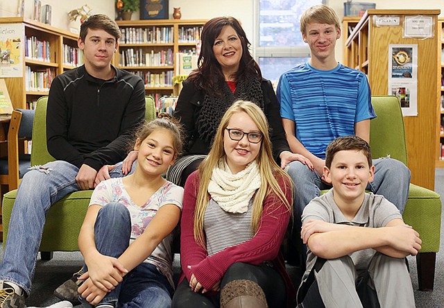 Julie Barker, center, sits with her family, from left, Thomas Barker, 17, Nick Barker, 14, Halie Eaton, 10, Alissa Barker, 18, and Noah Barker, 11, Friday at Blair Oaks High School.