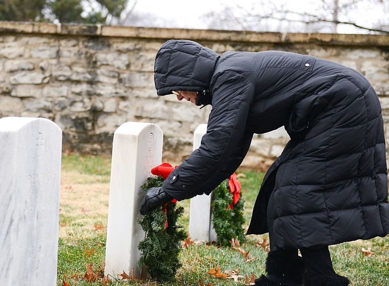 Sharon Naught gently places wreaths along a line of headstones Saturday, Dec. 17, 2016 at the National Cemetery on East McCarty Street in Jefferson City. Naught was volunteering with the Wreaths for Heroes organization, which placed a wreath on the graves of 1,587 veterans over the weekend.