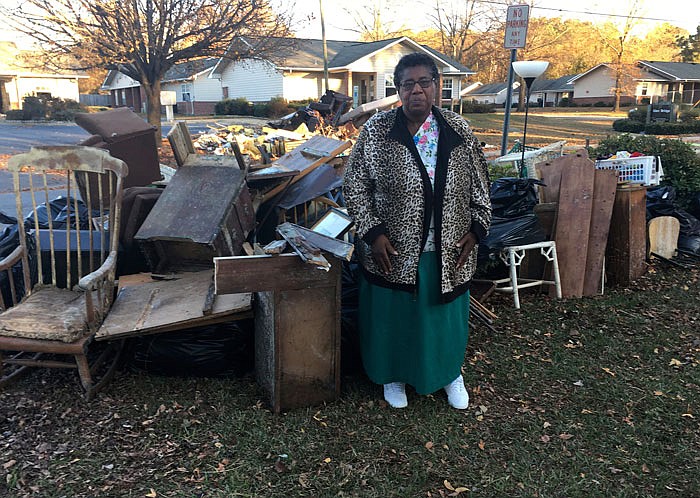Dianne Hines stands, Dec. 1, in front of the mound of furniture and other belongings pulled from her home after Hurricane Matthew in Princeville, North Carolina.