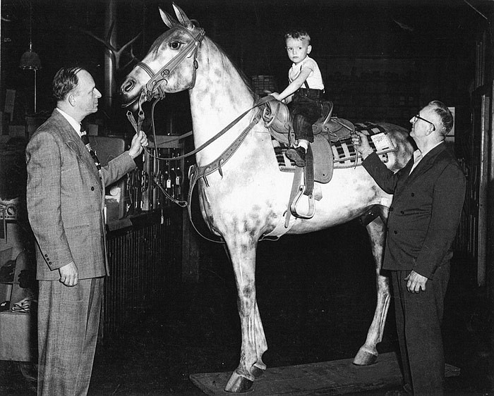 This undated photo shows the Heck horse with Heck Saddlery manufactured saddle and bridle. The people in the photo are unidentified.