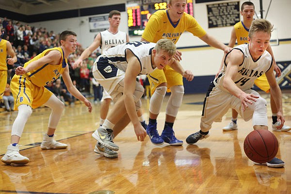 Helias teammates Landon Harrison (right) and Nathan Bax scramble for a loose ball during Wednesday night's game against Bolivar at Rackers Fieldhouse.
