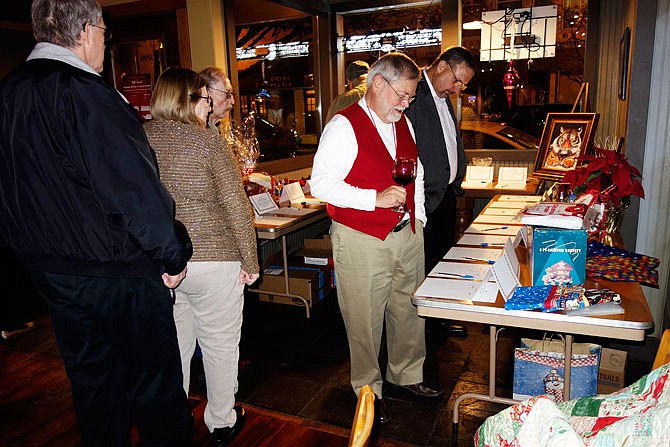 Callaway County resident Denton Kurtz (red vest) and others peruse the offerings at the Our House Silent Auction this week, raising funds to support the homeless shelters and their services in Fulton.
