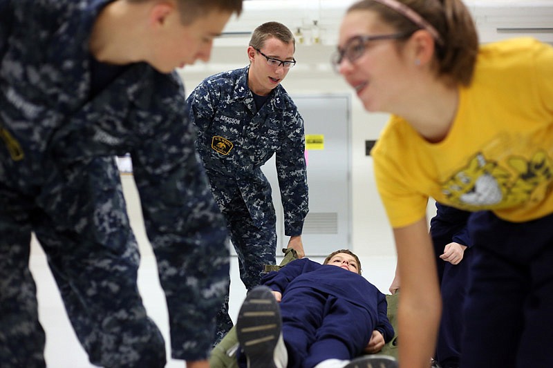 Sea Cadet Austin Atkisson, 17, leads a group Thursday in practicing "splint-a-wound" and "2-man litter carry" training at the Ike Skelton Training Site in Jefferson City. Cadets learned how to apply tourniquets, carry wounded comrades and basic first aid information.