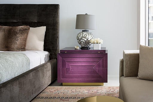 This photo provided by Brown Davis Interiors shows a rich purple console inside a penthouse apartment bedroom. Designed by Brown Davis and crafted by Keith Fritz Fine Furniture, the Barry console is part of a collection of richly-hued furniture that takes a cue from Art Deco and makes it thoroughly modern. (Moris Moreno/Brown Davis Interiors via AP)