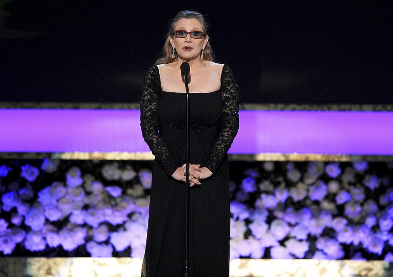 In this Jan. 25, 2015, file photo, Carrie Fisher presents the life achievement award on stage at the 21st annual Screen Actors Guild Awards at the Shrine Auditorium in Los Angeles. On Tuesday, Dec. 27, 2016, a publicist said Fisher has died at the age of 60.